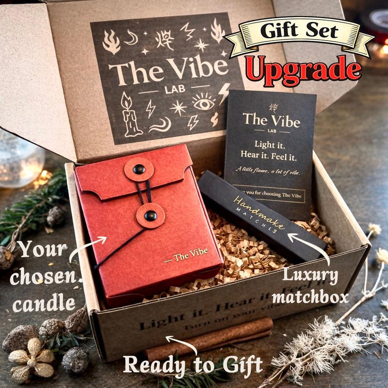 May include: A gift set in a cardboard box with the text "The Vibe Lab" and "Upgrade". The set includes a red envelope-style container, a black matchbox labeled "Handmade Matches", and a card with the text "Light it. Hear it. Feel it."