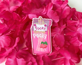 Puede incluir: Una pegatina rosa de una caja de Pocky con sabor a fresa, con el texto "Rocky Pocky" y fresas pixeladas. La pegatina está colocada sobre un fondo de pétalos de flores de color rosa brillante.