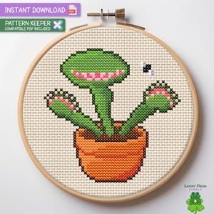May include: Cross stitch pattern of a green Venus flytrap plant with pink teeth in a brown pot. The plant has three mouths and a fly is flying above it.