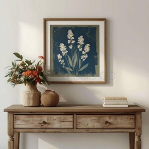 Stylized botanical painting featuring slender olive-green leaves and textured white flowers on a dark moody background. Square format digital art with a vintage aesthetic, perfect for modern farmhouse or cottagecore wall decor.