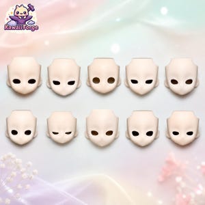 May include: Ten pale, smooth, resin doll head faceplates arranged in two rows of five. Each faceplate features a distinct eye shape, ranging from wide circular openings to narrow, almond-shaped slits, all with a pointed chin and blank expression.