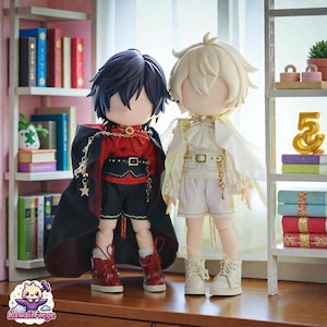 Peut inclure: Deux poupées de style anime, l'une vêtue de rouge et de noir avec une cape, l'autre de blanc et d'or. Les poupées sont debout sur une surface en bois devant une bibliothèque. La poupée de gauche a les cheveux foncés et des chaussures rouges.