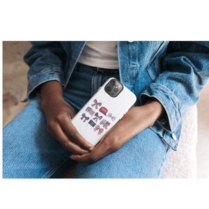 May include: A white phone case with a design of red, white, and blue bows, stars, and flags. The case is being held by a person wearing blue jeans.