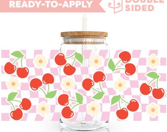 Può includere: Un barattolo di vetro trasparente con un coperchio di legno e una cannuccia. Il barattolo è decorato con un motivo a scacchi rosa e bianco e ciliegie rosse. Il testo "READY-TO-APPLY" e "DOUBLE SIDED" è visibile nell'immagine.