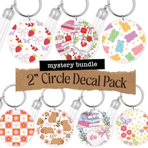 May include: A collection of round keychains with various designs, including strawberries, bows, books, and gummy bears. The keychains are 2 inches in diameter and feature silver key rings and clear plastic handles. The text "mystery bundle" and "2" Circle Decal Pack" are also visible.