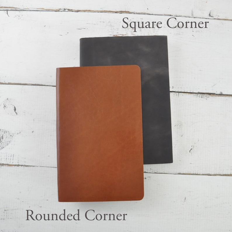 May include: Two leather-bound notebooks, one with rounded corners and one with square corners. The notebook with rounded corners is brown and the notebook with square corners is black.