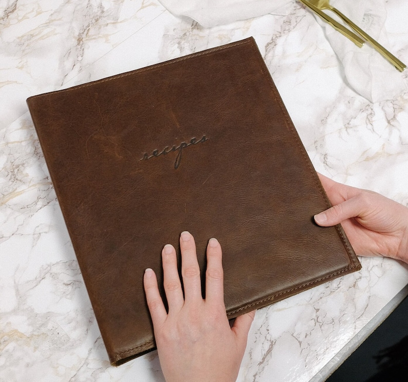 May include: A brown leather recipe binder with the word "recipes" embossed on the front cover.