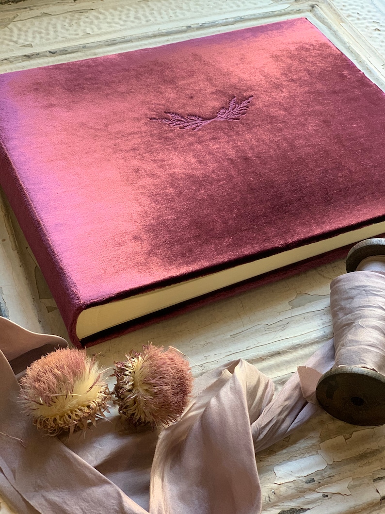 Luxurious, soft, velvet photo album. Shown in the 9x12 inch size, and wine velvet color. Options to personalize with one of our art emblems, or add your own text for additional cost. Wheat emblem shown here debossed in center of cover