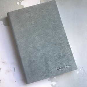 May include: A light blue leather-bound journal with the words "Badass Boss" embossed on the front cover.