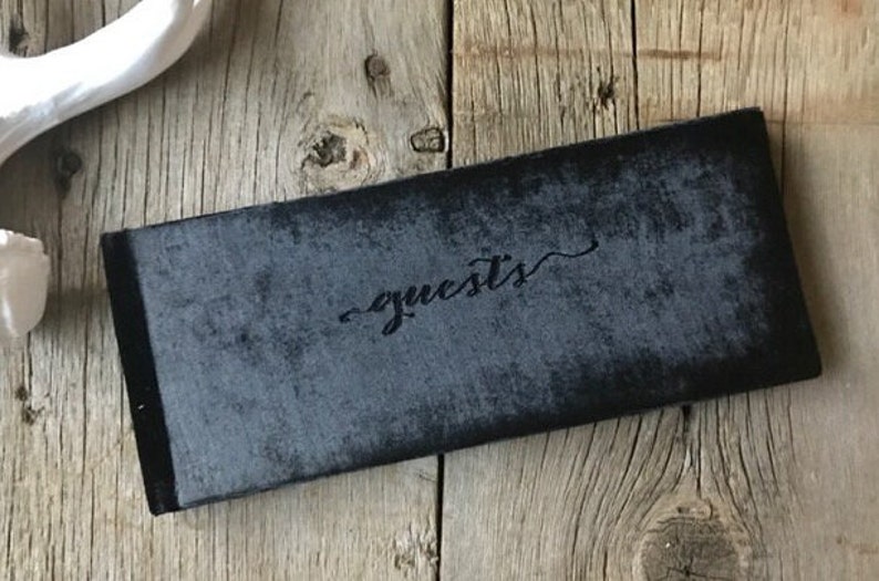 Small velvet guest book. 4x10 inches, landscape. Soft velvet cover in black color. Script guests stamped in center. Lined or blank page options available. Option to add name or date for added cost to the bottom right corner