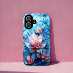May include: A phone case featuring a stained-glass style floral design. The case showcases a blue and teal background with a large, multi-layered lotus flower in shades of pink, purple, and orange. The design includes intricate details and a glossy finish.