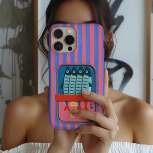Op de afbeelding: Een smartphonehoesje met verticale roze en blauwe strepen. Het midden toont een rechthoekige afbeelding van een sardineblikje met vier blauwe vissen, een horizontale oranje band en de tekst SAR en NET WT in het geel en wit.