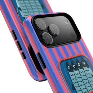 Op de afbeelding: Een smartphonehoesje met een patroon van verticale roze en blauwe strepen. De achterkant van het hoesje toont een rechthoekige afbeelding van vier gestileerde vissen die naast elkaar staan op een blauw veld met een dunne oranje rand.