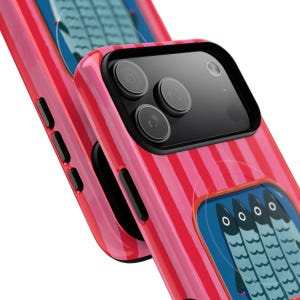 Op de afbeelding: Een felroze smartphonehoesje met een verticaal gestreept patroon en een rechthoekige afbeelding van vier gestileerde blauwe vissen die naast elkaar staan. Het hoesje heeft een zwarte camera-uitsparing met drie lenzen en zijknoppen.
