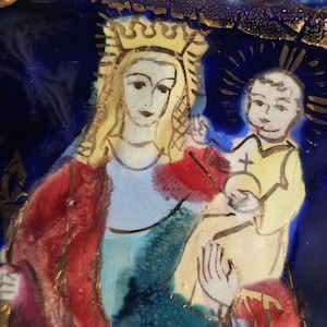 May include: A religious icon depicting a woman wearing a gold crown and holding a child. The artwork features a vibrant color palette of red, blue, yellow, and gold. The figures are set against a dark blue background with gold accents.
