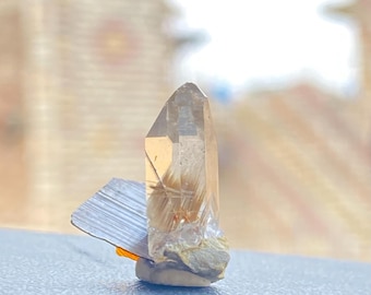 Raro ejemplar de cristal transparente con terminación en moscovita y cuarzo rutilado con brookita