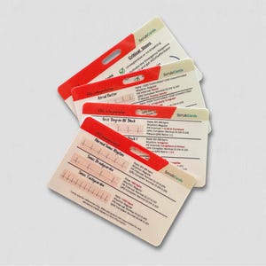 May include: A set of four white ScrubCards reference cards with red top borders, featuring medical EKG interpretation data, rhythm strips, and clinical guidelines. Each card includes text labels, heart rate data, and the ScrubCards brand name.