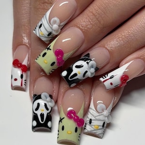 May include: A set of long, sculpted fingernails with a French manicure base. Each nail features a different Halloween-themed design, including a mummy, a ghost face, and a cat, all with 3D accents and bows.
