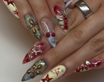 Y2K edgy grunge druk op de nagels, bloedrode uitstraling en 3D metalen kruis nepnagels, zilveren ster bedels stilettomanicure