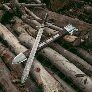 Full length view of a handmade Damascus steel Knight Templar Sword with patterned blade, hardwood handle, and wooden scabbard with steel accents