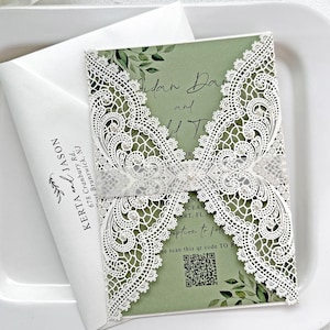 May include: Wedding invitation with a laser-cut white lace design over a green background. The invitation includes the names "Aidan Dan and ..." and a QR code. A white envelope with the names "Kerta and Jason" is also visible.
