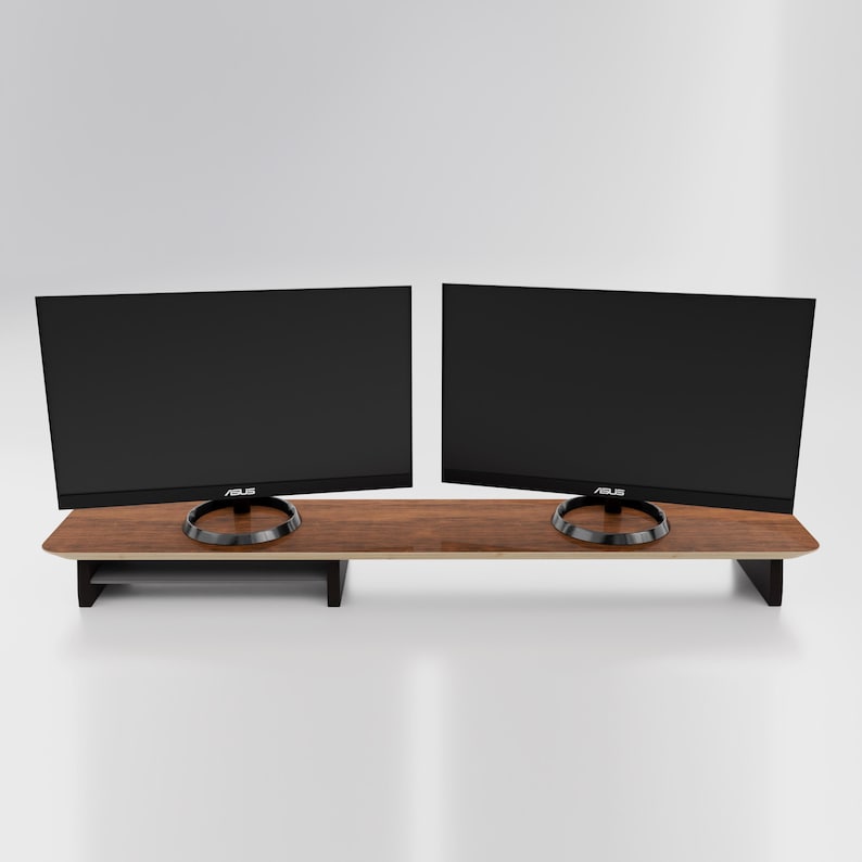 May include: A wooden monitor stand with two black computer monitors on top. The stand has a shelf underneath for storage.