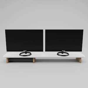 May include: White monitor stand with two black computer monitors on top. The monitors have black bezels and the text "ASUS" on the bottom. The stand has a lower shelf for storage.