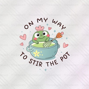 Puede incluir: Una ilustración caprichosa presenta una rana chef de dibujos animados en una olla azul, batiendo una mezcla verde. El texto dice "ON MY WAY TO STIR THE POT" en un diseño circular, con corazones y estrellas rosas. La rana lleva un gorro de chef rosa.