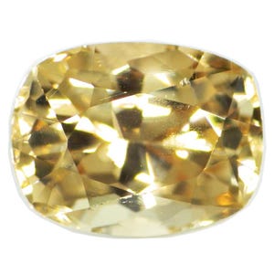 Puede incluir: Una piedra preciosa amarilla de talla cojín con una superficie facetada.