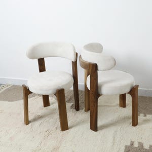 Minimalist Wooden Chair with soft white upholstery. Scandinavian-inspired modern accent chair for living rooms or stylish dining areas.