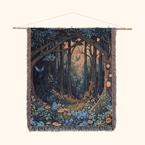 May include: A rectangular woven tapestry featuring a dark forest scene with tall trees, blue birds, and orange and blue flowers. The tapestry has a fringed edge and is suspended from a wooden rod with a string for hanging, displaying a detailed landscape.
