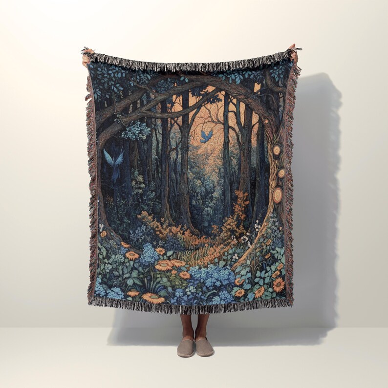 Fantasy woven blanket featuring an enchanted forest scene with glowing trees, wildflowers, and blue birds, inspired by cottagecore and fairycore aesthetics.