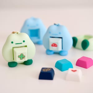 Op de afbeelding: Een witte keramische mok met een zwart handvat en de tekst "But first, coffee" in handschriftstijl. De mok staat op een wit oppervlak. De mok is ongeveer 10 cm hoog.