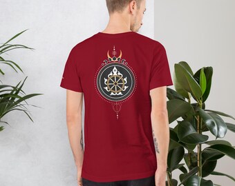 May include: A red t-shirt featuring a black and white graphic of a Dharmachakra, a Buddhist symbol representing the wheel of life. The graphic is encircled by a circle of gold and white dots.