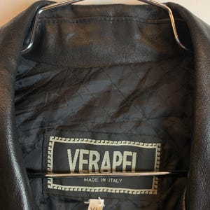 May include: Black leather jacket with a quilted lining. The label reads "VERAPEI MADE IN ITALY" and includes an XL size tag. The jacket is hanging on a metal hanger.