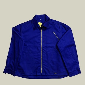 Könnte beinhalten: Kornblumenblaue Jacke mit durchgehendem Messingreißverschluss und passender Reißverschlusstasche. Die Jacke hat einen Kragen und zwei Vordertaschen. Ein gelbes Etikett hängt am Kragen.