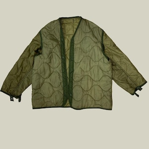 Può includere: Giacca trapuntata verde oliva con scollo a V. La giacca presenta un motivo a rombi e una chiusura con bottoni sul davanti. Le maniche hanno cinturini regolabili sui polsini. Questa giacca leggera è adatta per la stratificazione e l'abbigliamento casual.