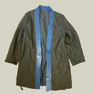 Può includere: Giacca trapuntata verde oliva con colletto e pannelli anteriori in denim. I pannelli in denim presentano dettagli strappati. La giacca ha una vestibilità ampia e maniche a tre quarti. Un capo spalla unico ed elegante.