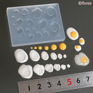 May include: A clear silicone mould with 18 different sized egg shapes. There are 12 pre-made white egg shapes and 6 yellow yolk shapes. A ruler is included for size reference.