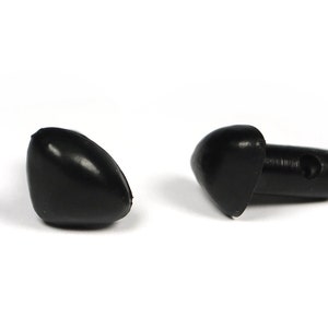 Puede incluir: Dos ojos de seguridad de plástico negro con un agujero para coser. Los ojos tienen forma de lágrima y tienen una parte posterior plana.