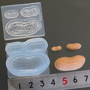 May include: Clear silicone mold with three peanut shapes, two small and one large.  The mold is labeled "C-720".  Three peanut candies are shown next to the mold, one small, one medium, and one large.