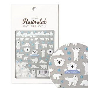 May include: A sheet of clear resin stickers featuring white polar bears in various poses, including standing, sitting, and lying down. The stickers also include snowflakes and a banner that reads "POLAR BEAR".