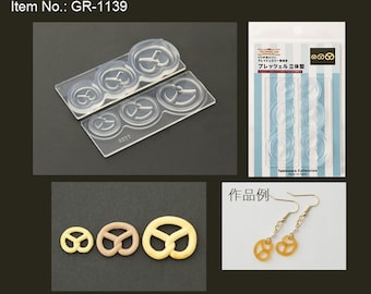 Peut inclure: Moule en silicone transparent avec quatre formes de bretzels de différentes tailles. Le moule est présenté à côté d'un emballage avec le texte "Clay Jewelry Line Pretzel 3D Mold" et une photo de boucles d'oreilles réalisées avec le moule. Le texte "作品例" est affiché à côté des boucles d'oreilles.
