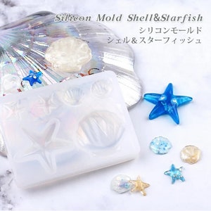 Pode incluir: Um molde de silicone transparente com 7 cavidades para fazer artesanato de resina. O molde apresenta desenhos de estrela do mar e conchas. A imagem também mostra exemplos de peças de resina acabadas, incluindo uma estrela do mar azul, uma concha branca e uma concha brilhante.