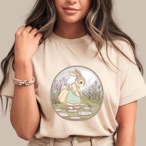 Bunny Garden Sweeping Shirt | Whimsical Cottagecore Bunny Tee | Cute Spring Animal T-Shirt | Floral Nature Graphic | Pastel Garden Vibes