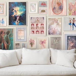 May include: A white couch with white pillows in front of a wall with framed artwork. The artwork features ballet dancers, flowers, and other decorative designs. The frames are white and have a simple design.
