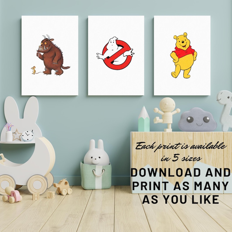 May include: Three printable nursery art prints featuring illustrations of the characters from the children's books 'Where the Wild Things Are', 'Ghostbusters', and 'Winnie the Pooh'. The prints are on a white background and are displayed on a wall in a child's room.