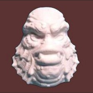 May include: White plaster sculpture of a creature with a textured, scaly face and a wide, open mouth.