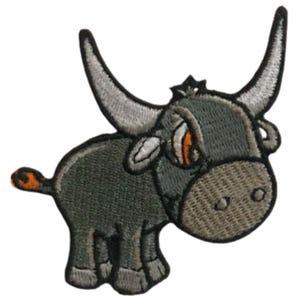 May include: Embroidered iron-on patch of a cartoon grey bull with orange eyes and a white horn. The bull is standing with its head tilted to the side.