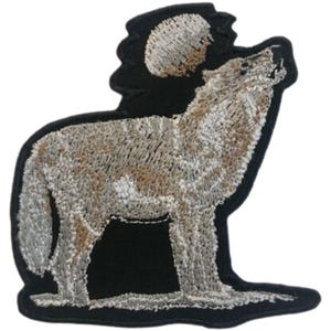 Puede incluir: Parche bordado para planchar con un lobo gris aullando a la luna. El lobo está de pie sobre un suelo blanco nevado con un fondo negro.